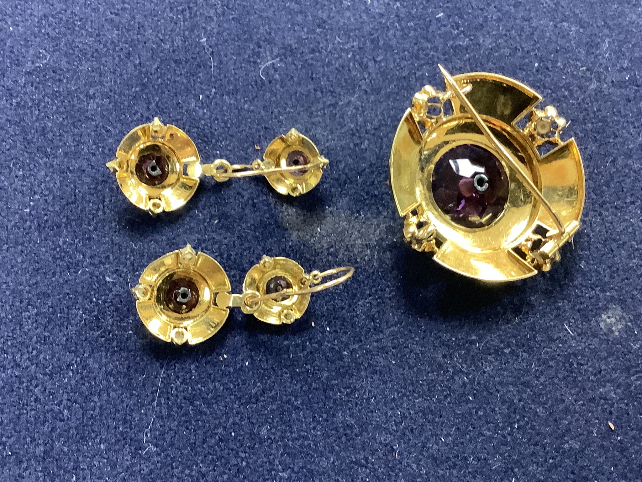 A cased continental Victorian style yellow metal, amethyst paste and seed pearl set demi parure, comprising a brooch and pair of matching earrings, brooch 35mm, earrings overall 37mm, gross weight 12.8 grams.